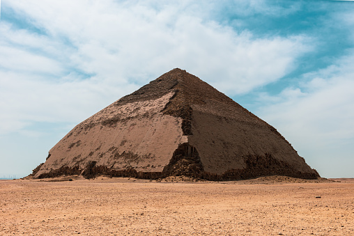 The Bent Pyramid is an ancient Egyptian pyramid located at the royal necropolis of Dahshur, approximately 40 kilometres south of Cairo, built under the Old Kingdom Pharaoh Sneferu (c. 2600 BC). A unique example of early pyramid development in Egypt, this was the second pyramid built by Sneferu.