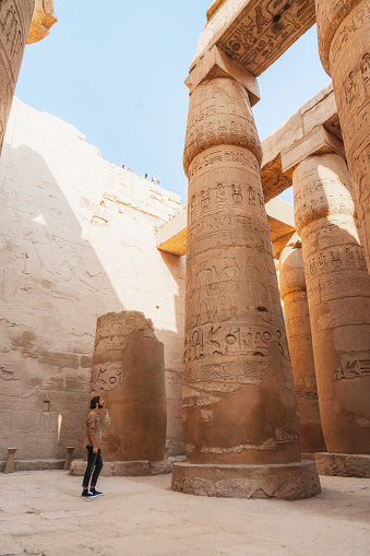 Young Caucasian man walking in the ancient Egyptian temple in Luxor