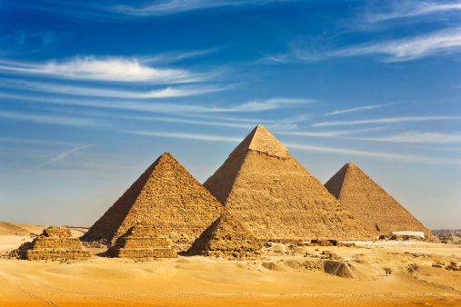 "Egypt. Cairo - Giza. General view of pyramids from the Giza Plateau (there is three pyramids popularly known as Queens' Pyramids on front side; next in order from left: the Pyramid of Menkaure /Mykerinos/, Khafre /Chephren/ and Chufu /Cheops/ - known as the Great Pyramid). The Pyramid Fields from Giza to Dahshur is on UNESCO World Heritage List"